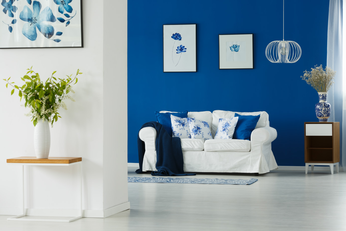 A bright, blue-walled living room featuring floral possible decor by an Engineering Consultancy in Abu Dhabi.