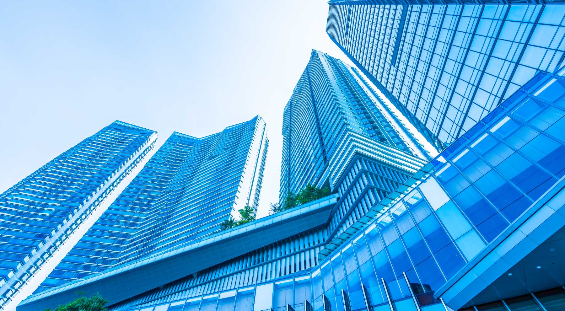 A low-angle view of modern glass skyscrapers possibly managed by an Engineering Consultancy in Abu Dhabi.